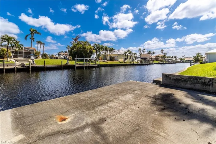Dock with a residential view, a boat ramp, and a water view