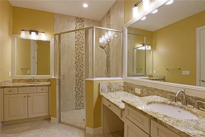 Bathroom with a shower stall and two vanities