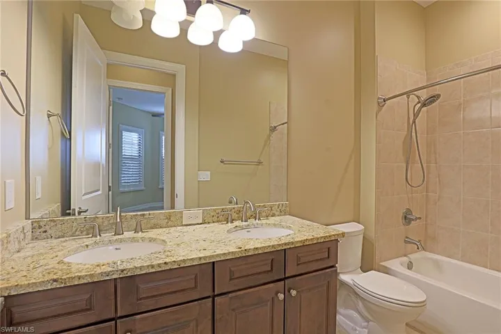 Bathroom featuring double vanity and bathing tub / shower combination