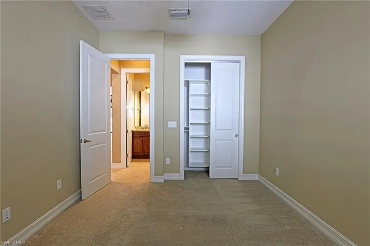 Unfurnished bedroom featuring light colored carpet and a closet