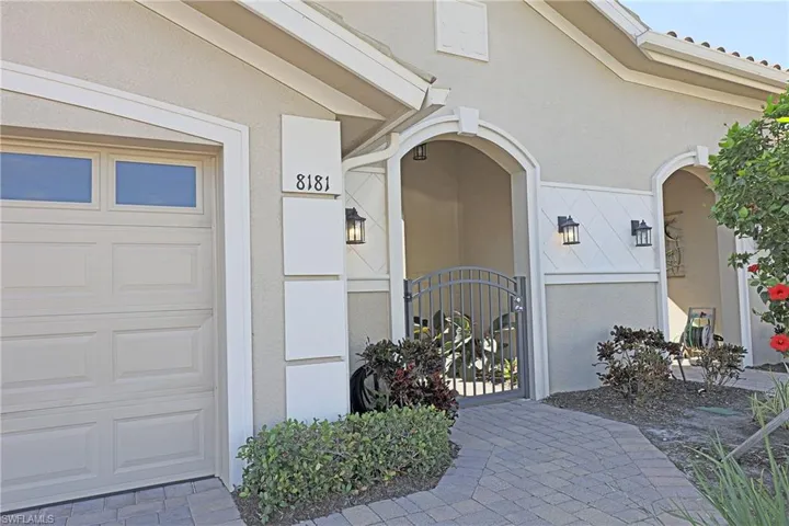 Doorway to property featuring a gate, stucco siding, and a garage