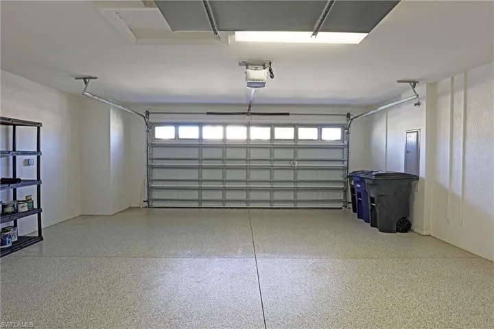 Garage featuring a garage door opener and electric panel