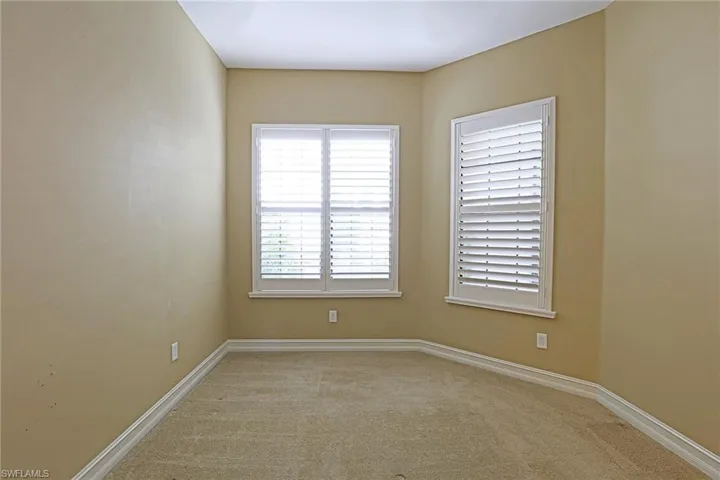 Spare room with light colored carpet and baseboards