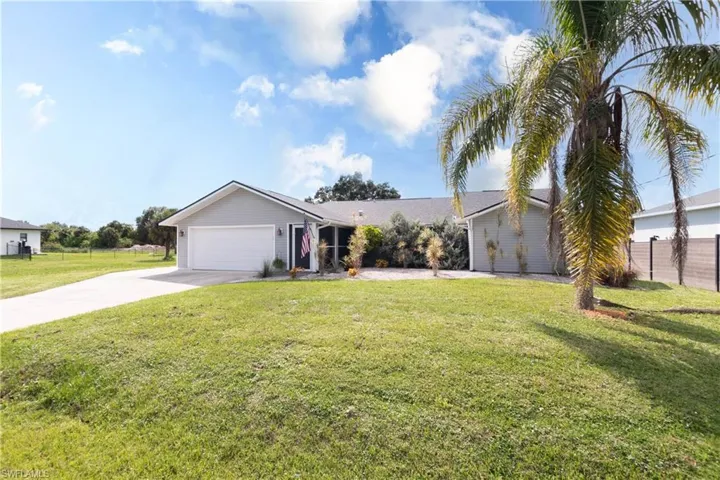 View of front of home with concrete driveway and an attached garage
