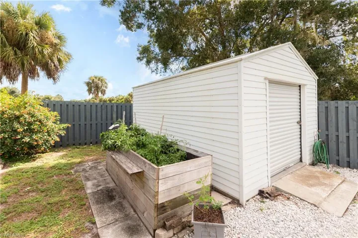 View of shed with a vegetable garden and a fenced backyard