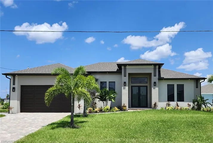 View of front facade featuring a garage and a front yard