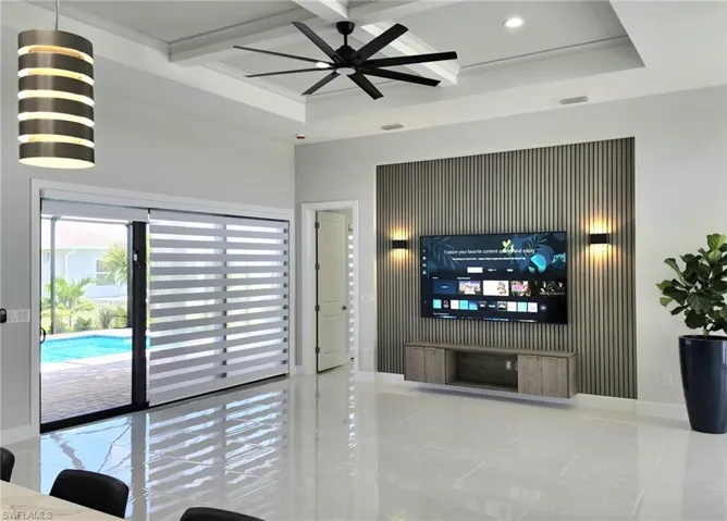 Tiled living room featuring beam ceiling, ceiling fan, and coffered ceiling