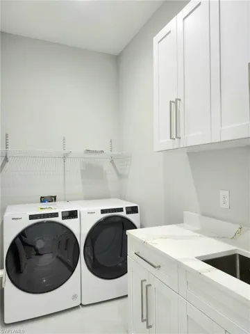 Laundry room featuring cabinets and independent washer and dryer
