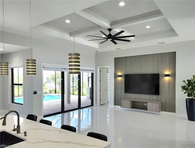 Tiled living room featuring ceiling fan, coffered ceiling, sink, and beam ceiling