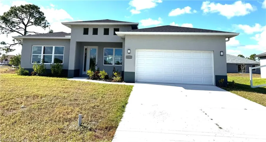 Prairie-style home featuring a garage and a front lawn