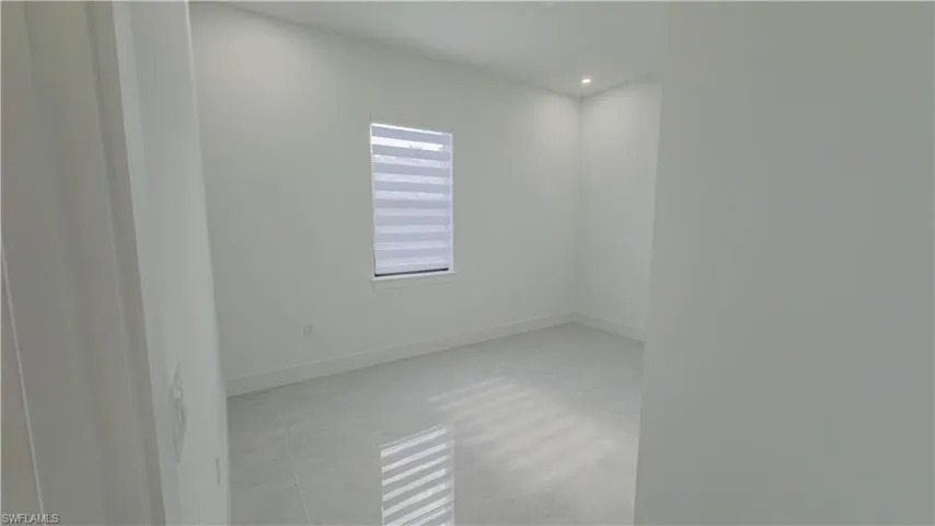 Empty room with baseboards and recessed lighting