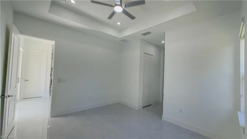 Spare room featuring a tray ceiling, recessed lighting, and ceiling fan