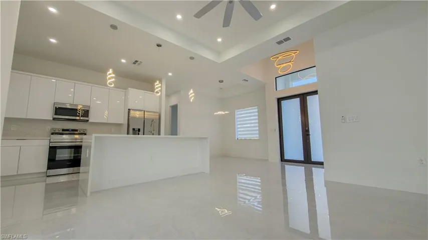 Kitchen featuring white cabinets, decorative light fixtures, modern cabinets, appliances with stainless steel finishes, and recessed lighting