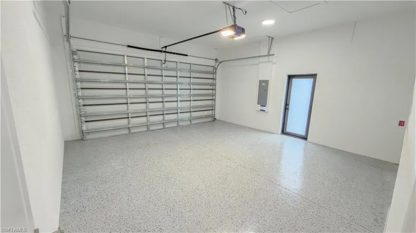 Garage with electric panel and a garage door opener