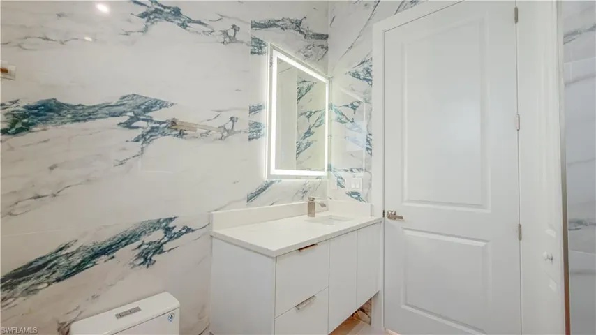 Half bathroom featuring vanity and toilet