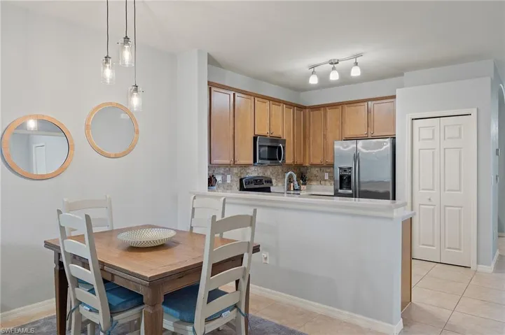 Kitchen with backsplash, pendant lighting, light tile patterned floors, and stainless steel appliances