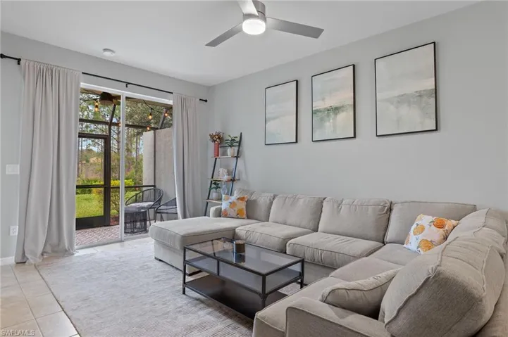 Living room featuring light tile patterned floors and ceiling fan