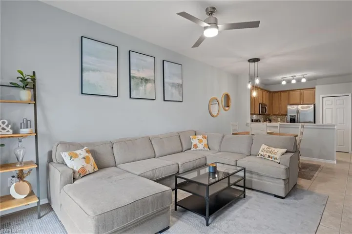 Living room with light tile patterned flooring and ceiling fan