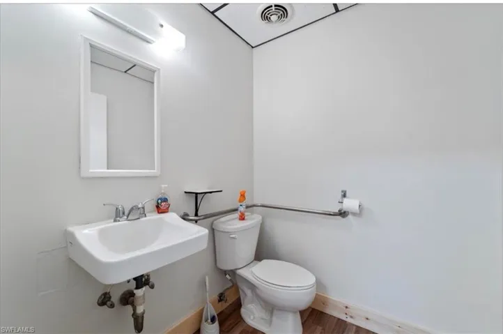 Half bath with toilet and wood finished floors