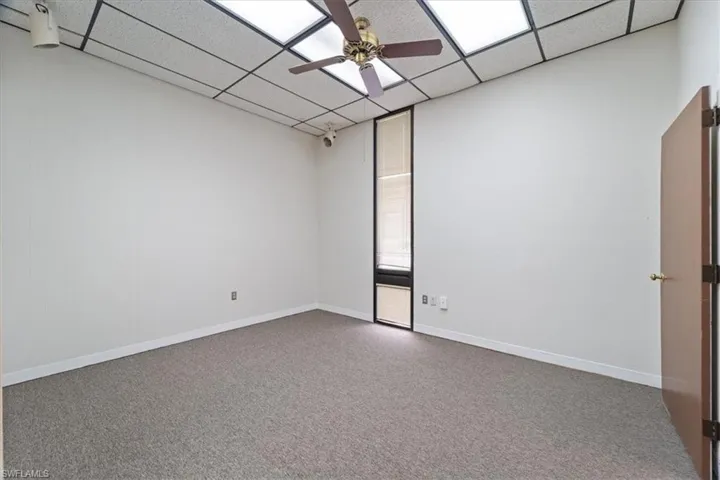 Empty room with a ceiling fan and a paneled ceiling