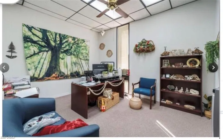 Office with ceiling fan, a paneled ceiling, and carpet