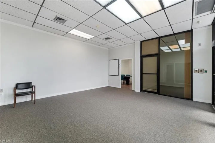Empty room featuring carpet flooring and a drop ceiling