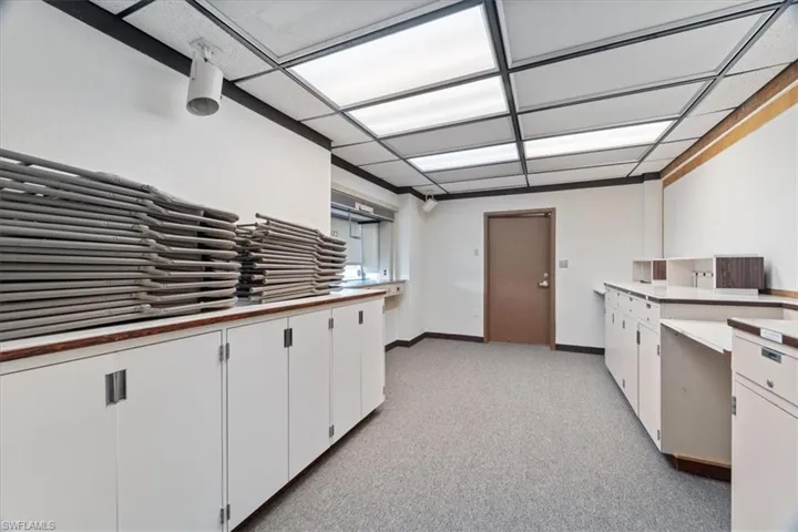 Kitchen featuring white cabinetry, light carpet, and light countertops