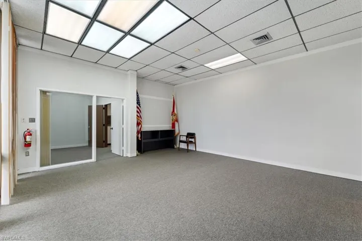 Carpeted spare room featuring baseboards and a paneled ceiling