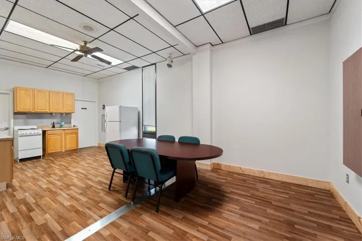 Dining room with a paneled ceiling, light wood-style floors, and ceiling fan