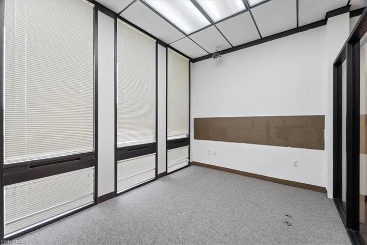 Spare room featuring light carpet and a drop ceiling