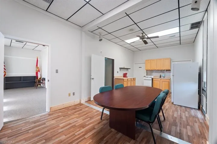 Dining space featuring a ceiling fan, light wood-type flooring, and a drop ceiling