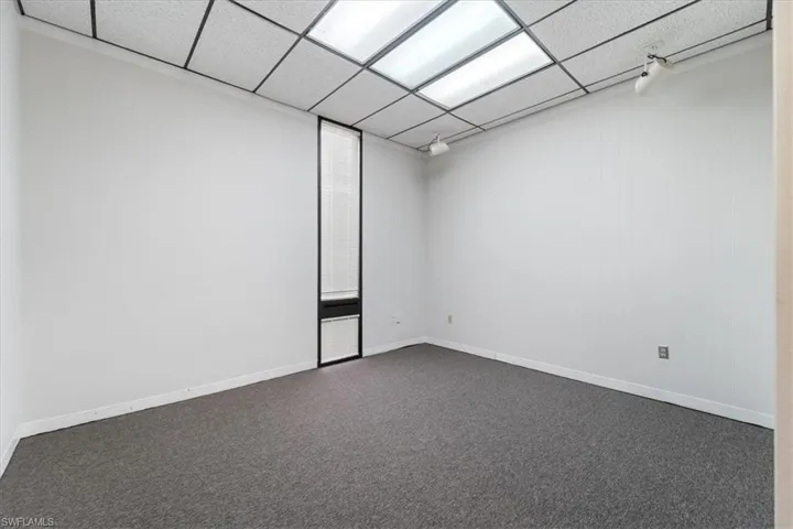 Empty room featuring carpet and baseboards