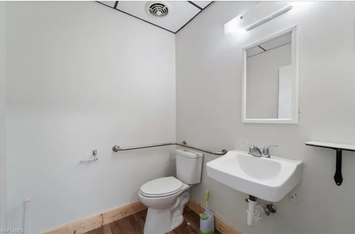 Bathroom with toilet and wood finished floors