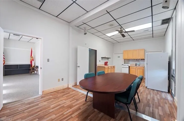 Dining area with ceiling fan, light wood-style flooring, and a drop ceiling