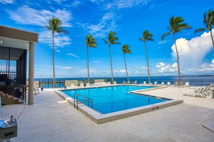 Community pool featuring a patio area, and a water view