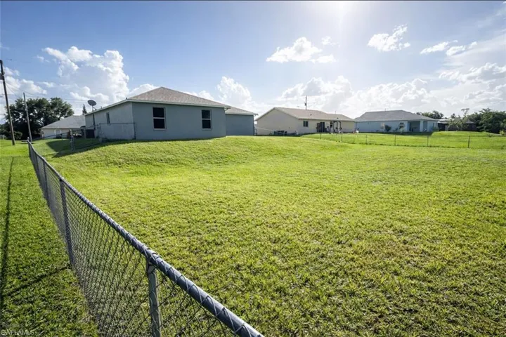 Rear view of house featuring a fenced backyard