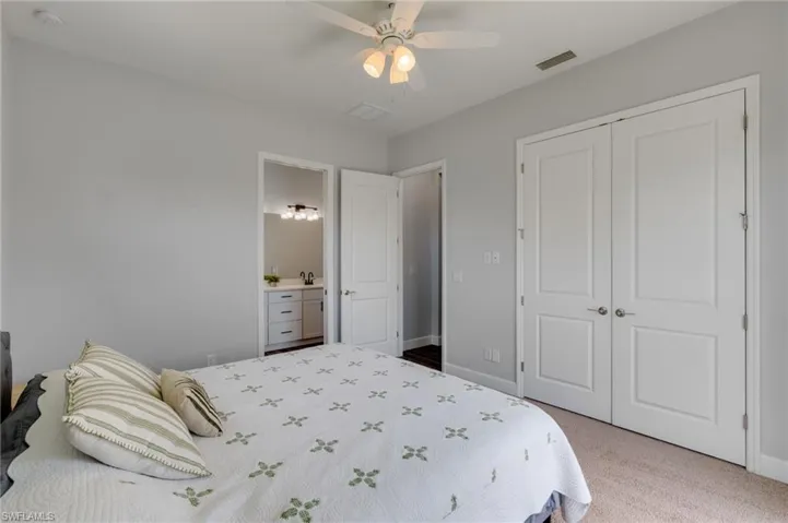Bedroom with light gray walls and beige carpet flooring