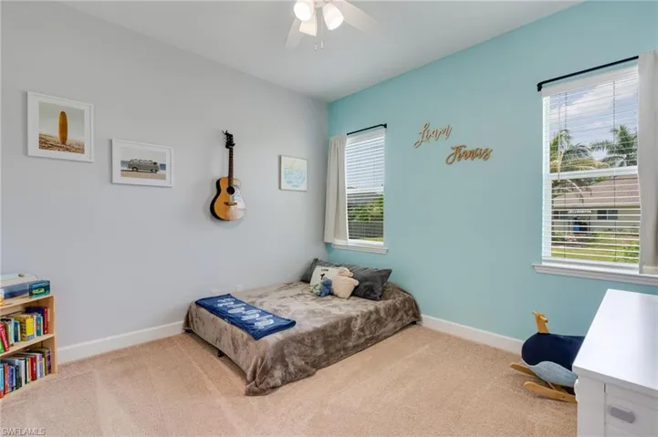 Spacious room with plush carpet flooring and a ceiling fan