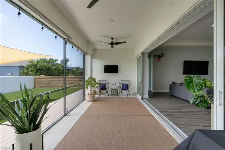 Covered outdoor patio featuring a ceiling fan and string lighting