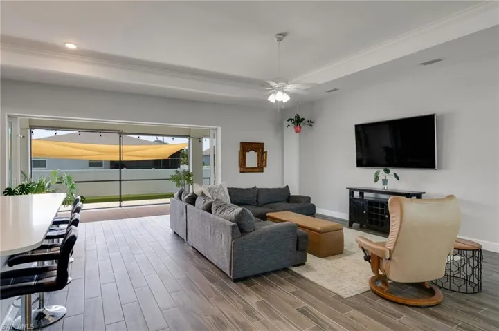 Spacious interior featuring wood-look tile flooring, crown molding, and recessed lighting