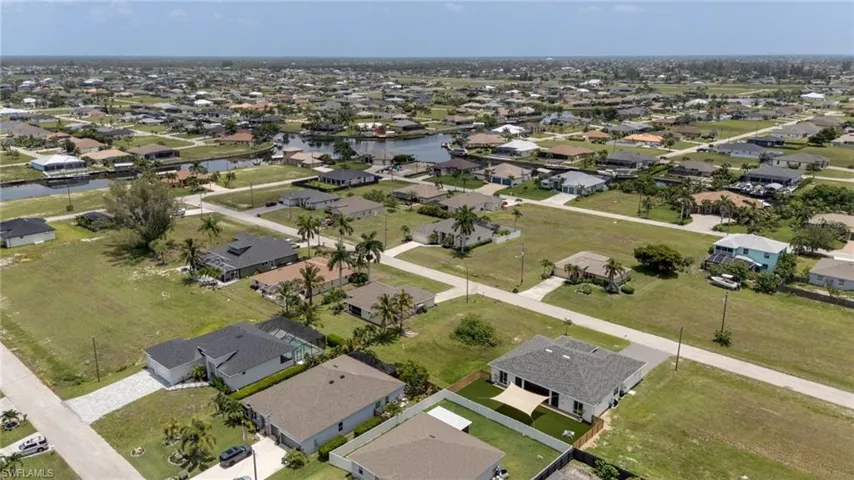 Expansive residential area featuring numerous single-story homes, a canal system, and undeveloped lots