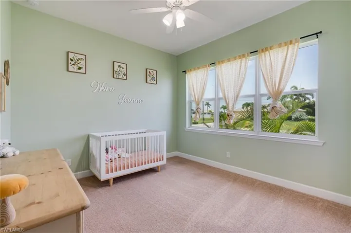 Room featuring soft green walls, a light-colored carpet, and a white ceiling fan
