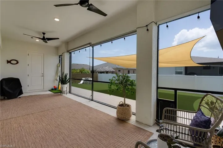 Screened lanai featuring dual ceiling fans and recessed lighting. Access to a half bath.