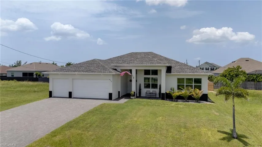 Modern single-story residence with a light-colored exterior and dark trim accents