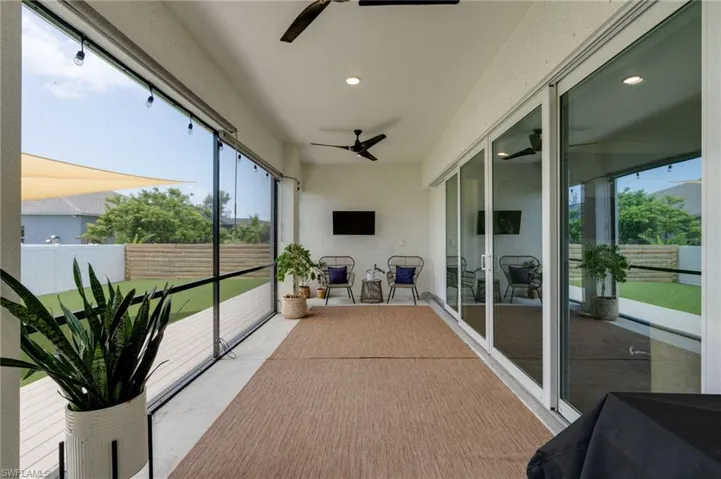 Covered patio featuring screen enclosure, sunshades, and white sliding glass doors