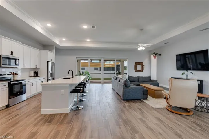 Expansive view of entire living area, kitchen, and sliders.