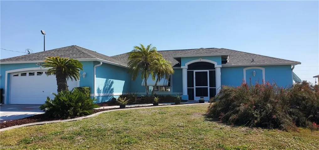 Ranch-style home with a front lawn, a shingled roof, stucco siding, and a garage