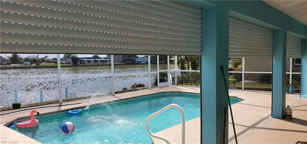 Pool featuring a patio and a lanai with Electric Hurricane Shutters