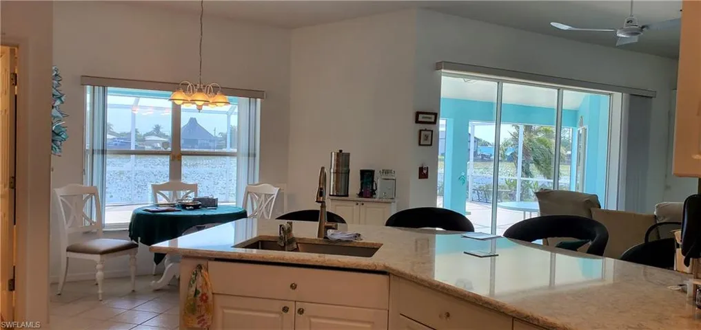 Kitchen with pendant lighting, a sink, a healthy amount of sunlight, and light tile patterned floors