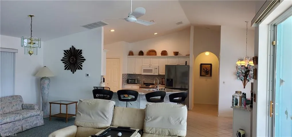Living room featuring light tile patterned floors, recessed lighting, ceiling fan, and visible vents
